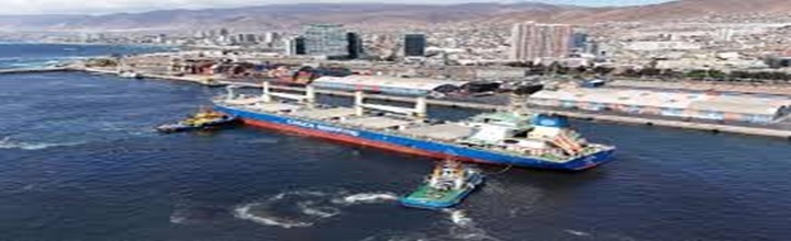 Convoy de camiones en ruta hacia la zona portuaria de Antofagasta, escala de grises con bandera de Chile sutil