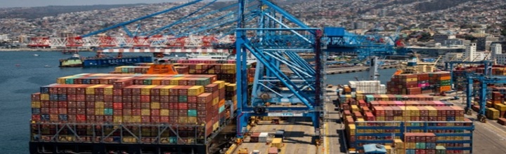 Carguero costero navegando frente a la costa chilena con faro