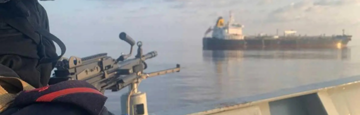 Tanker y lanchas rápidas al anochecer en el océano Índico, escena ilustrativa de riesgo de piratería